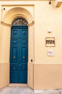 a blue door on the side of a building at Spinola Stays in St. Julianʼs