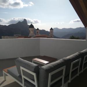 een stoel en tafel op een balkon met uitzicht op de bergen bij Central House at Tejeda's Heart with Amazing View in Tejeda
