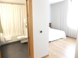 Un baño con una cama y un inodoro en una habitación. en Posada Miranda, en Miranda del Castañar 37 fotos más