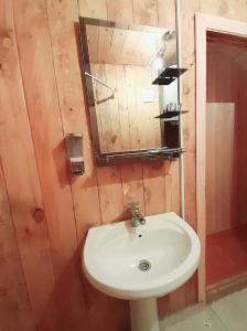 a bathroom with a white sink and a mirror at Hotel Arkhoti in Akhieli