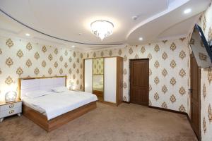 - une chambre avec un grand lit et un miroir dans l'établissement Hotel DREAM PLAZA, à Boukhara