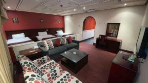 una camera d'albergo con divano e letto di Al Mansour Grand Hotel a Hafr Al Baten
