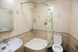 La salle de bains est pourvue d'un lavabo, de toilettes et d'une douche. dans l'établissement Hotel DREAM PLAZA, à Boukhara