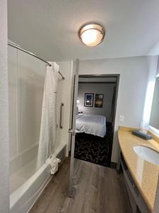 a bathroom with a tub and a bedroom with a bed at La Quinta by Wyndham Big Spring in Big Spring