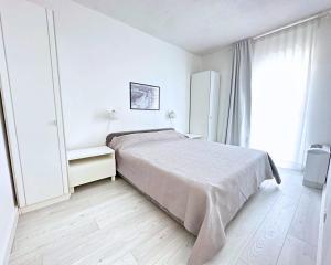 ein weißes Schlafzimmer mit einem Bett und einem Fenster in der Unterkunft The Martinez Holiday House - Zadar in Zadar