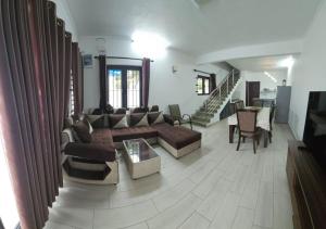 a living room with a couch and a table at 3 Bedroom Family Pool Villa Flic-en-Flac Beach in Flic-en-Flac