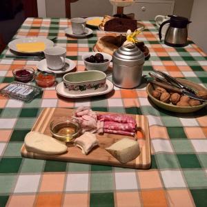 uma mesa com uma bandeja de queijo e outros alimentos em B&B Alla Borgata em Boves