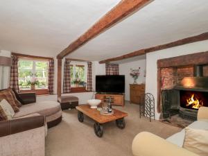 a living room with a couch and a fireplace at 2 Pigsfoot Cottages in Tiverton