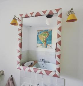 a bathroom mirror with a red and white stripe around it at Peaceful cottage with private garden in Hailsham