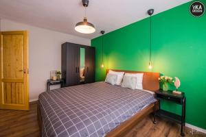 ein Schlafzimmer mit einem Bett mit einer grünen Wand in der Unterkunft Park Apartment 23 in Alba Iulia