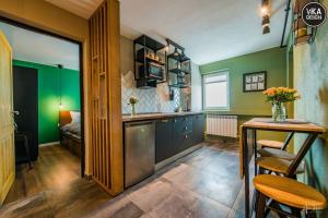 eine Küche mit grünen Wänden, einem Tisch und einem sidx sidx sidx in der Unterkunft Park Apartment 23 in Alba Iulia