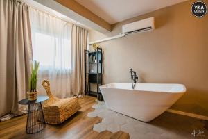 Un baño con una gran bañera blanca y una ventana. en Park Apartment 23, en Alba Iulia 13 fotos más