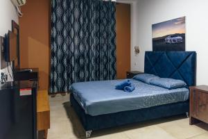 a bedroom with a blue bed with a teddy bear on it at Central Laguardia Hotel in Tel Aviv