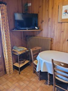 a dining room with a table and a tv at Chalet Le Starfu in Crest-Voland