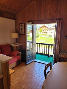 una sala de estar con una puerta que da a un balcón en Chalet Le Starfu, en Crest-Voland