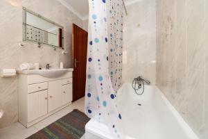 uma casa de banho com uma banheira branca e um lavatório. em Nazaré Landscape em Nazaré