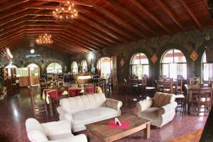 a living room with white couches and tables and chairs at Hotel Tiosh Abaj in Santiago Atitlán