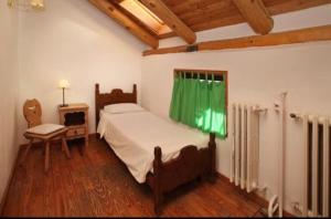 una camera con un letto e una sedia e una finestra di Hotel Derby Bar a Sauze d'Oulx
