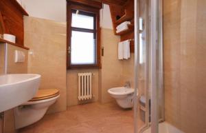 bagno con lavandino, servizi igienici e finestra di Hotel Derby Bar a Sauze d'Oulx