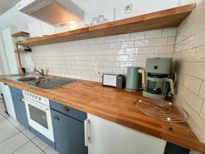 a kitchen with a wooden counter top with a sink at Apartment Entenbrücke in Wendlingen am Neckar