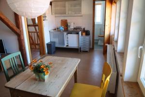 une cuisine avec une table en bois et des fleurs. dans l'établissement Ferienwohnung Am Westerntor 1, à Wernigerode 7 autres photos