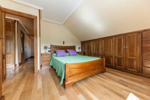 een slaapkamer met een bed met paarse kussens en houten kasten bij El Pongallin ideal para familias in Sevares