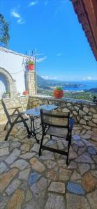a table and a bench on a stone patio at Castle of Himara in Himare
