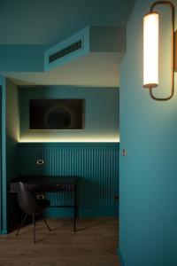 Habitación con silla y TV en la pared en Hotel Miro', en Garda