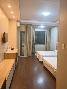 Cette chambre comprend deux lits et une télévision. dans l'établissement Can ho Muong Thanh, à Cửa Lô
