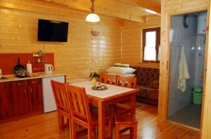 a kitchen with a table and chairs in a cabin at Domki Kazimierz in Darłowo