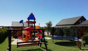 a playground with slides and trampols in a yard at Domki Kazimierz in Darłowo