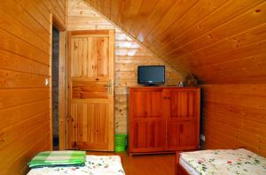 a room with a bed and a television in a cabin at Domki Kazimierz in Darłowo +13 photos