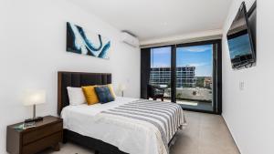 1 dormitorio con cama y ventana grande en Brand New Condo Aria Ocean 501 by Kivoya, en Nuevo Vallarta 