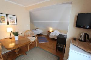 una pequeña sala de estar con mesa y sofá en Bed & Breakfast Villa Sedin, en Härnösand