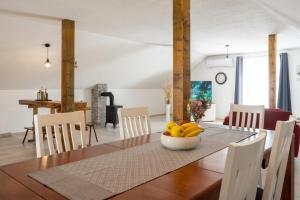 una sala da pranzo con tavolo e cesto di frutta di Holiday House Zrmanja Vrelo a Krupa