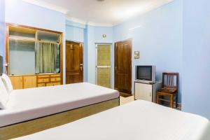 um quarto com 2 camas e uma televisão em OYO Flagship Hotel Digantika em Bālugān