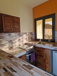 a kitchen with a sink and a stove top oven at DEKK JAMM, où l'on trouve la paix in Toubab Dialaw