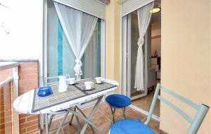 einen Balkon mit einem Tisch und 2 blauen Stühlen in der Unterkunft Beautiful Apartment In Benicarló in Benicarló + 8 Fotos