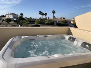 een hot tub op het dak van een huis bij Casa Saudade - Luxury penthouse apartment with stunning views in Estômbar