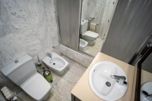 łazienka z umywalką, toaletą i lustrem w obiekcie Piso en Fuente de las Batallas w Grenadzie +18 zdjęć