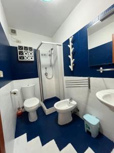 uma casa de banho azul e branca com um WC e um chuveiro em Umberto Street em Catânia