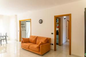 un divano arancione in soggiorno con tavolo di Casa Ritella - ApulianStay Group a Monopoli