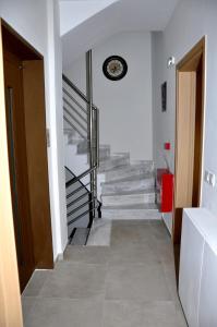a hallway with stairs and a clock on the wall at Alkioni's Nest Apartments in Arkoudi