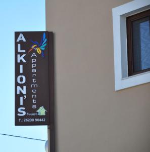 a sign on the side of a building next to a window at Alkioni's Nest Apartments in Arkoudi
