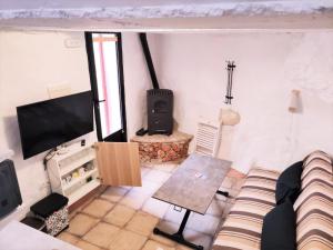een woonkamer met een bank en een flatscreen-tv bij CÁNTARO. Las Puertitas Rojas in Ubrique