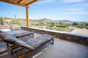a balcony with a bench and a view of the ocean at SeaeyeVillas 2 in Livadi