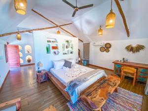 a bedroom with a large bed and a desk at Ananda Beach Hotel in Paje