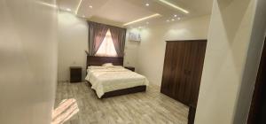 1 dormitorio con cama y ventana. en وحدات جنان en Ahad Rafidah