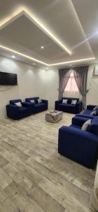 a living room with blue couches and a flat screen tv at وحدات جنان in Ahad Rafidah