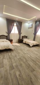 a large room with two beds and a large window at وحدات جنان in Ahad Rafidah